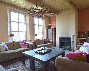 Gezellige woonkamer in Huisje in Winterswijk Woold, vakantiehuis in de Achterhoek, Gelderland met knusse zithoek en sfeervolle open haard.