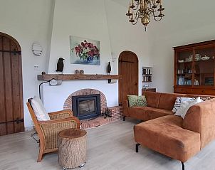 Gezellige woonkamer van Vakantiehuisje in Winterswijk Woold, Achterhoek, Gelderland met open haard en comfortabele zithoek.