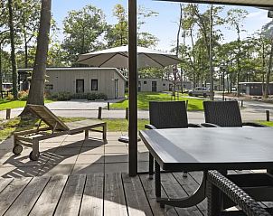 Ruim terras van De Vlinderhoeve 2C, Kring van Dorth, met ligstoel en eettafel.