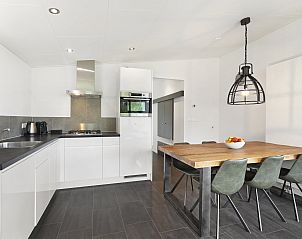 Strakke keuken in De Vlinderhoeve bungalow, voorzien van moderne apparatuur in Gelderland.