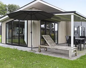 Terras met ligstoel en parasol bij De Vlinderhoeve, genieten van de natuur in Achterhoek.