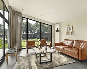 Stijlvolle woonkamer met leren bank in De Vlinderhoeve, vakantiehuis in Kring van Dorth, Gelderland.