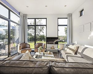 Lichte binnenruimte van De Vlinderhoeve bungalow in Gelderland met uitzicht op de natuur.