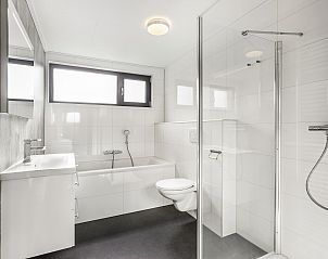 Luxe slaapkamer in De Vlinderhoeve bungalow met moderne kunst aan de muur.