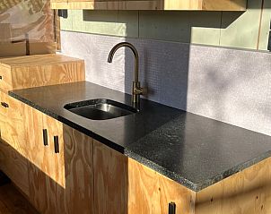 Modern kitchen in Cottage in Winterswijk - Meddo, vacation home in the Achterhoek region, Gelderland. Stylish design with wooden cabinets and natural stone countertops.