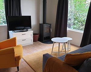 Stijlvolle woonkamer met TV en houtkachel in vakantiehuis Winterswijk Ratum, Achterhoek, Gelderland.