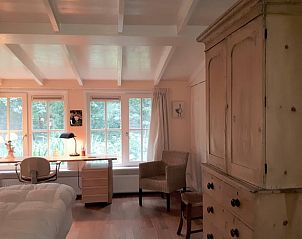 Cozy bedroom in Holiday Home in Joppe, Achterhoek, with wooden furniture and views of green nature through large windows.