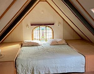 Cozy bedroom in Holiday Home in Joppe, Achterhoek, Gelderland with rustic attic ambiance and charming window.
