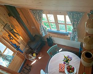 Gezellige binnenruimte van Vakantiehuisje in Winterswijk Corle, Achterhoek, met houten interieur en sfeervolle houtkachel.