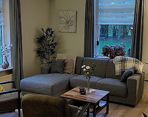 Gezellige woonkamer in Vakantiehuis in Winterswijk Corle, Achterhoek, met comfortabele zithoek en uitzicht op de groene natuur van Gelderland.
