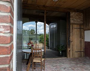 Knusse veranda van Huisje in Winterswijk met uitzicht op groene omgeving in Huppel, Achterhoek, Gelderland.