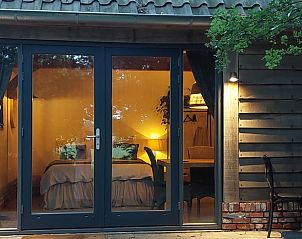 Gezellige slaapkamer van Huisje in Tonden, vakantiehuis in de Gelderse vallei, met warme verlichting en uitzicht op de natuur.