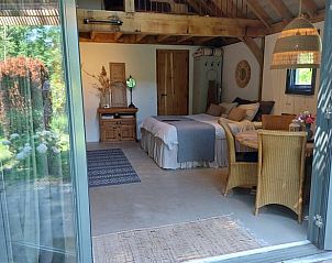 Gezellige binnenruimte van Huisje in Tonden, een vakantiehuis in de Gelderse vallei, Gelderland, met rustieke houten details en tuinzicht.