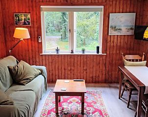 Gemtliches Wohnzimmer im Ferienhaus in Beekbergen, Veluwe, mit Blick auf die grne Umgebung.