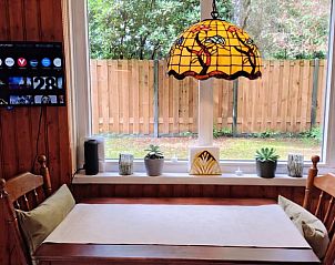 Essecke im Ferienhaus in Beekbergen, Gelderland, mit Blick auf den grnen Garten.