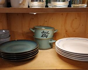 Kchenschrank mit Geschirr in einem Ferienhaus in Beekbergen, Gelderland, einschlielich Glser und Teller.