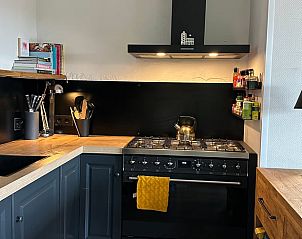 Gemtliches Schlafzimmer in Cottage in Beekbergen, Ferienhaus in Veluwe, Gelderland, mit bequemem Stuhl und modernem Kleiderschrank.