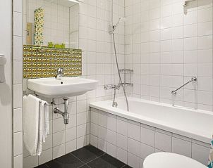 Moderne badkamer met douche en bad in Heideheuvel 4-persoons kinderbungalow, Beekbergen, Veluwe, Gelderland.