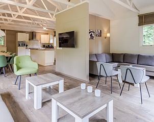 Gezellige woonkamer van Heideheuvel 18-persoons bungalow in Beekbergen, Veluwe met comfortabele zitruimte.