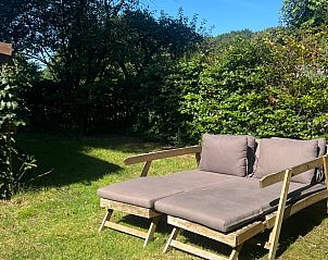 Comfortable deck chairs in the garden of Holiday home in Beekbergen, Veluwe, surrounded by greenery in Gelderland.