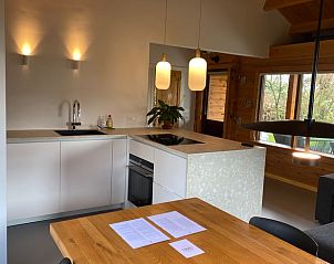 Dining area and kitchen of cottage in Beekbergen, Veluwe, with warm atmosphere in Gelderland.