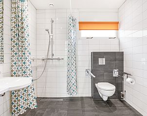 Lichte zithoek in Heideheuvel 4-persoons bungalow, Beekbergen, Veluwe, met uitzicht op de omliggende natuur.