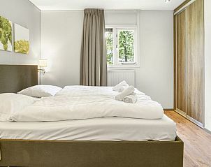 Comfortabele slaapkamer in Heideheuvel bungalow, Beekbergen, Veluwe, met groot bed en natuurlijk licht.