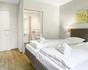 Slaapkamer met toegang tot badkamer in Heideheuvel bungalow, Beekbergen, Veluwe, voor extra gemak.