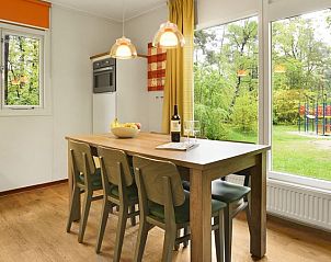 Eetkamer met uitzicht op speeltuin in Heideheuvel kinderbungalow, Beekbergen, Veluwe.