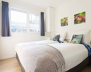 Sfeervolle slaapkamer in Ferox XL 4 personen Wellness vakantiehuis, Beekbergen, Veluwe, met comfortabel bed en natuurlijke lichtinval.