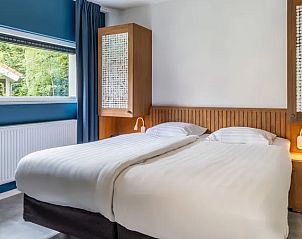 Slaapkamer met uitzicht op de natuur in Heideheuvel 10-persoons bungalow, Beekbergen, Veluwe.