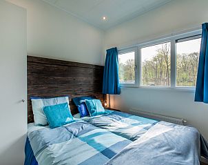 Gemtliches Schlafzimmer in Lodge fr 4 Personen, Ferienhaus in Beekbergen, Veluwe, Gelderland, mit Blick auf die umliegende Natur.