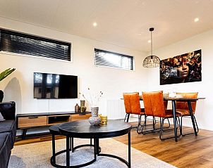 Gezellige leefruimte in Module Wood 4 personen vakantiehuis in Ede, Veluwe met flatscreen-tv en sfeervolle verlichting.