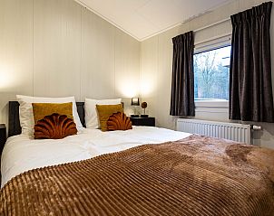 Ruime slaapkamer in Luna vakantiewoning, Ede, Veluwe, met grote ramen en uitzicht.