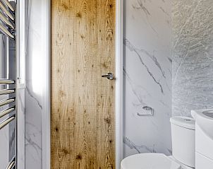 Badkamer van Module Nova vakantiehuis in Ede, Veluwe, met toilet en houten deur.