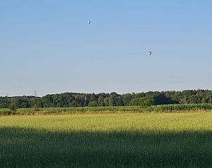 Zonsondergang boven de velden bij Huisje in Ede, Veluwe, met luchtballonnen.