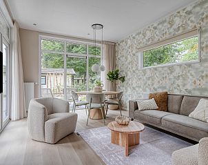 Stijlvolle woonkamer in Lindenhof, Ede, Veluwe met grote ramen en comfortabele zitplaatsen.