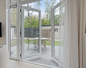 Open deuren naar terras bij Lindenhof vakantiehuis, Ede, Veluwe met tuinzicht.