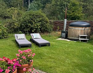 Tuin van Vakantiehuis in Ede met ligstoelen en hot tub, Veluwe, Gelderland.