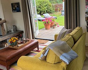 Comfortabele woonkamer met uitzicht op tuin in Vakantiehuis in Ede, Veluwe, Gelderland.