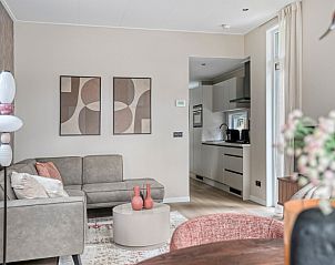 Gezellige zithoek in Wilgenhof vakantiehuis, Ede, Veluwe, met comfortabele bank en decoratieve elementen.