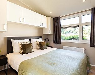 Slaapkamer met tweepersoonsbed in Boslodge Silva, vakantieaccommodatie in Ede.