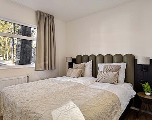 Slaapkamer in Module Exclusief vakantiehuis in Ede, Veluwe, Gelderland, met comfortabel bed en grote ramen.