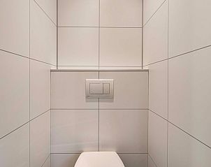 Modern toilet in Module Exclusief vakantiehuis in Ede, Veluwe, Gelderland, met strakke witte tegels.