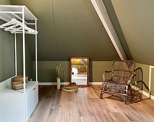 Cozy corner with chair in attic room of cottage in Emst, Veluwe, Gelderland.