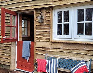 Gezellig terras bij Huisje in Emst met bank en decoratieve kussens, ideaal voor ontspanning in Veluwe, Gelderland.