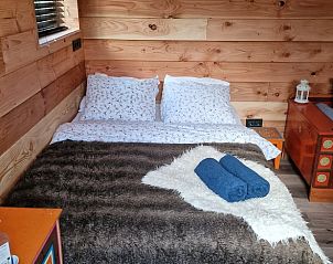 Rustieke slaapkamer van Huisje in Emst met zachte dekens en houten interieur in Veluwe, Gelderland.