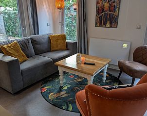 Cozy living room in Holiday home in Emst, Veluwe. Comfortable sitting area with colorful decorations in this vacation home in Gelderland.