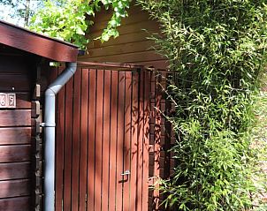 Houten toegangspoort van Vakantiehuisje in Emst, Veluwe, omgeven door bamboe.