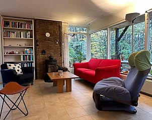 Cozy living room of Holiday Home in Emst, located in Veluwe, Gelderland, with comfortable seating and views of nature.